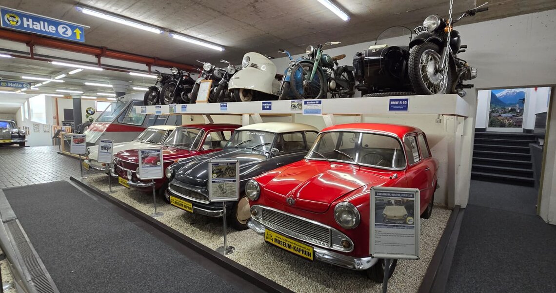 Oldtimermuseum Kaprun mit klassischen Autos und Motorrädern in Ausstellungshalle. | © Vötter's Oldtimermuseum